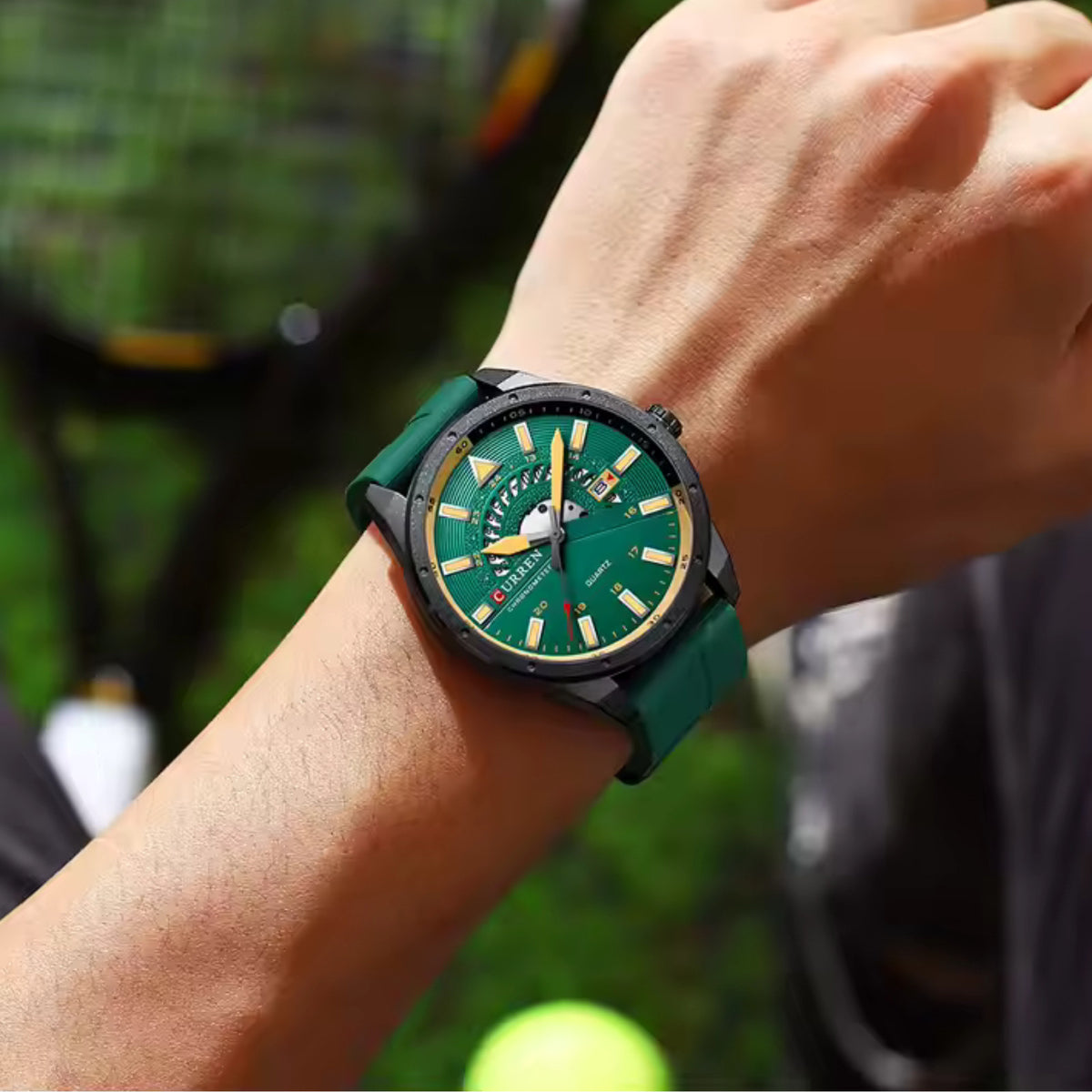 CURREN 8421 green-dial quartz watch worn on the wrist on a tennis court
