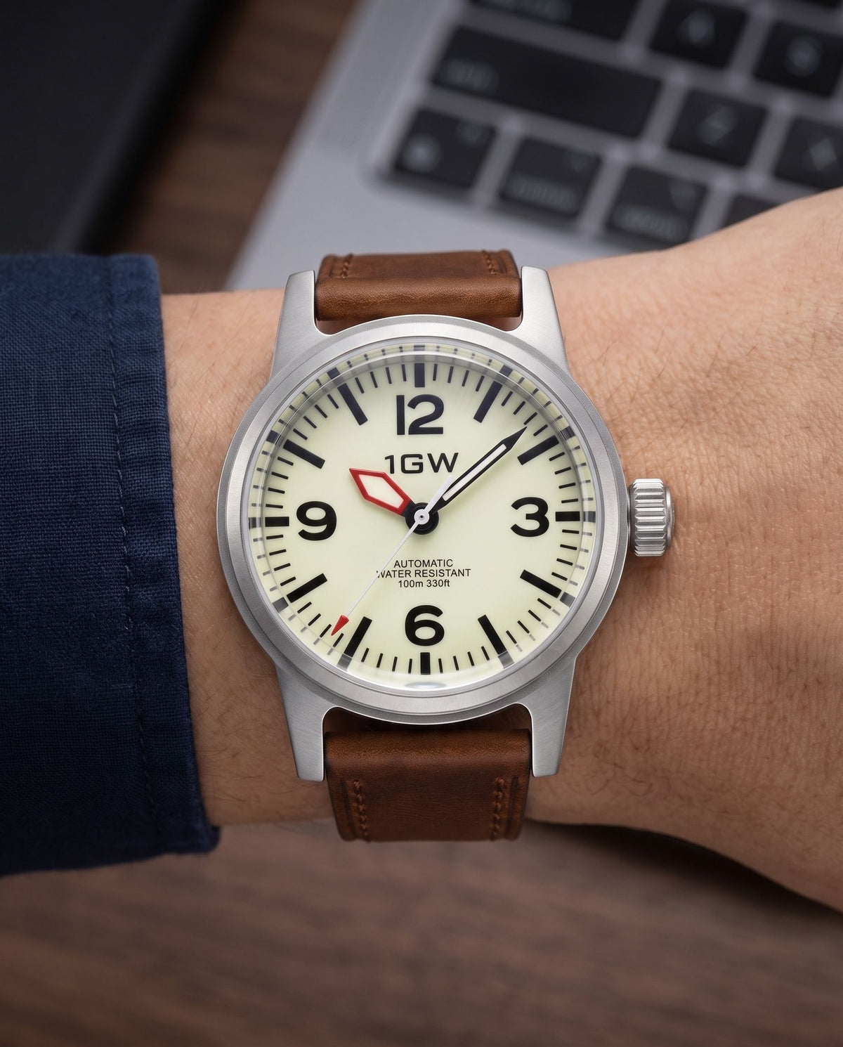 1GW Cream Field 36mm worn on the wrist beside a keyboard