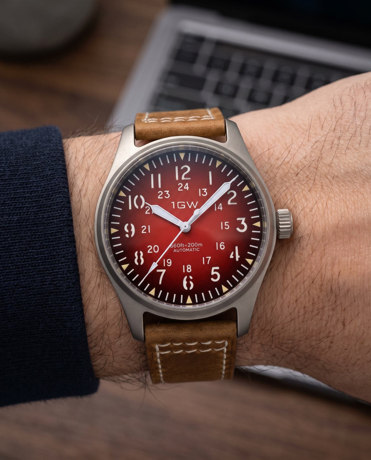 1GW Titanium Red GMT 36mm worn on the wrist beside a keyboard