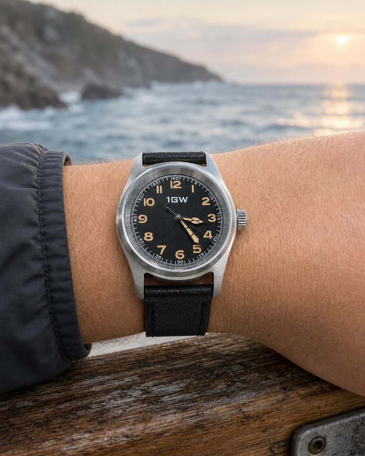 Black field automatic 36mm watch worn by a coastal rail