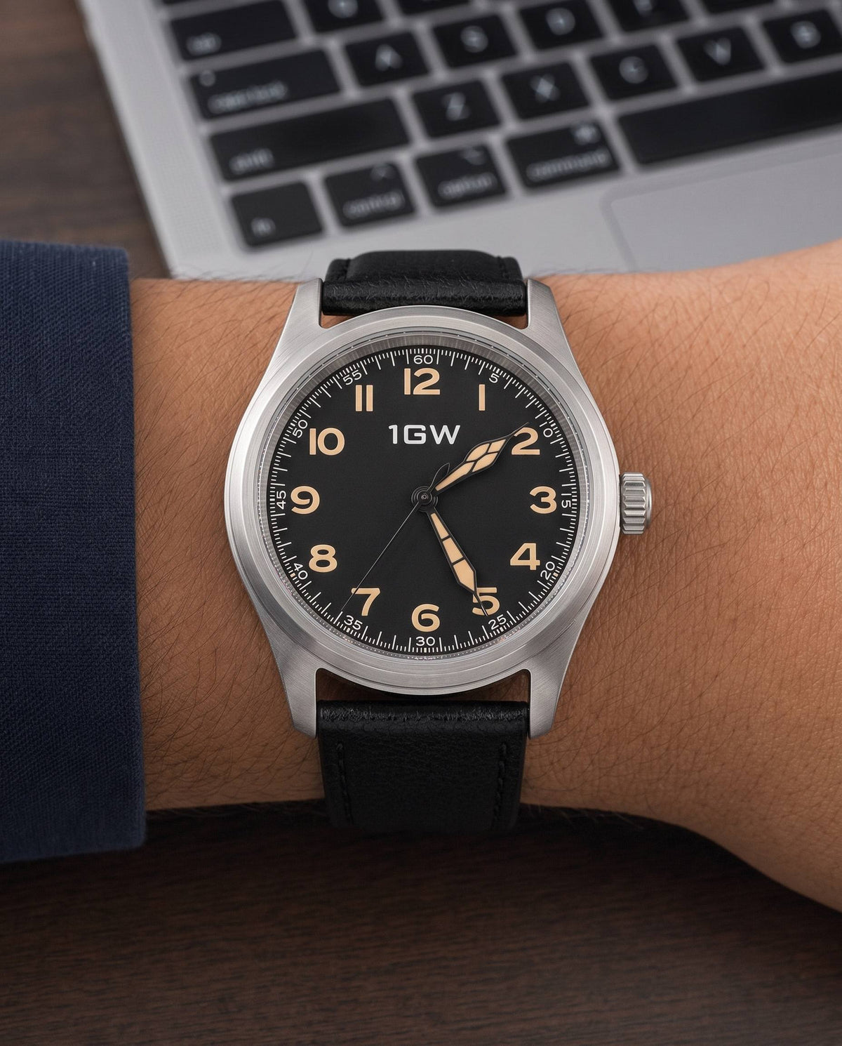 Black field automatic 36mm watch worn beside a keyboard