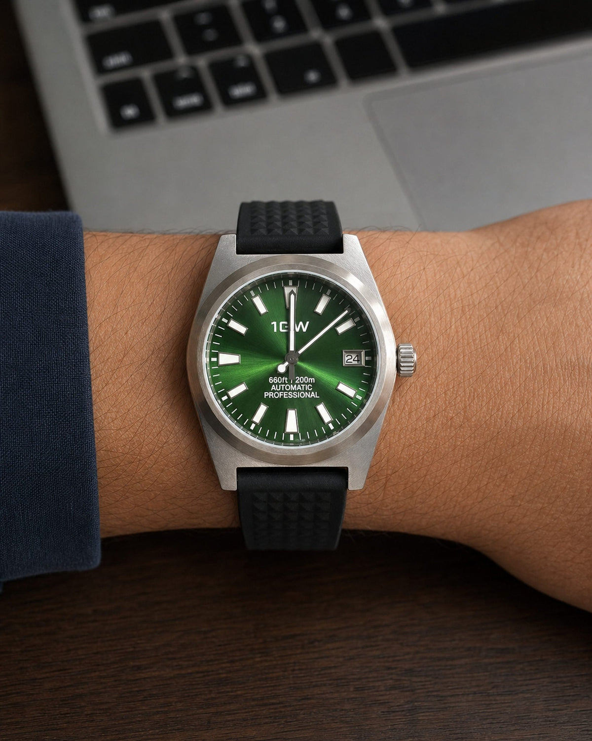 1GW Green Professional Diver automatic watch with green dial and black rubber strap beside a laptop