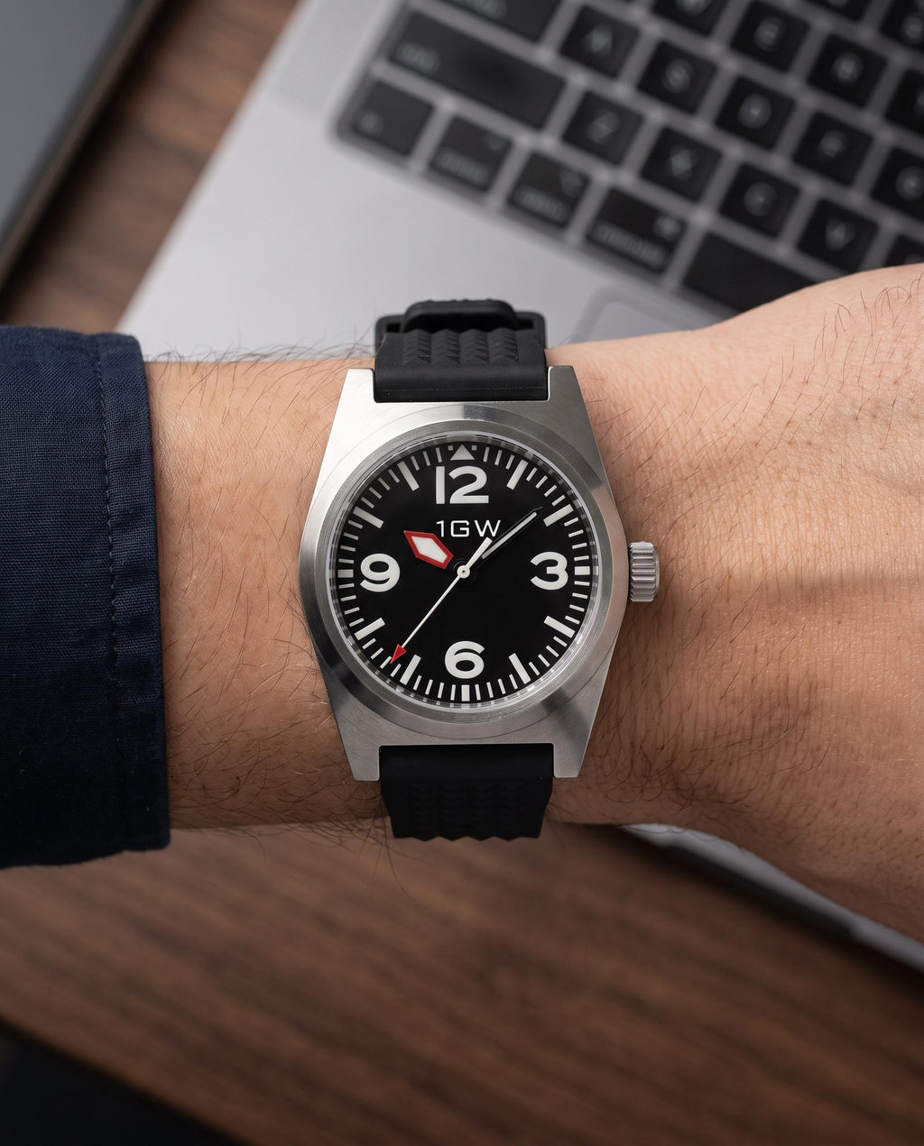 1GW Black Explorer PT5000 38mm worn on the wrist beside a keyboard, black waffle rubber strap