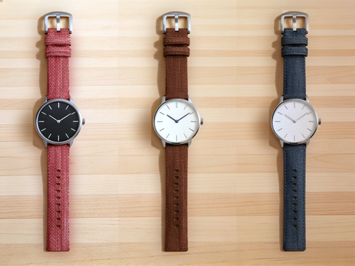 1GW Red, Coffee Brown and Dark Blue braided canvas watch straps, top-down flat lay on a light maple wood table