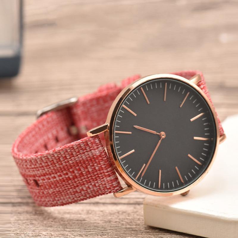 Red braided canvas quick-release watch strap styled on a watch