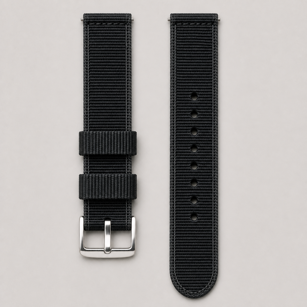 Black woven nylon quick-release watch strap laid flat in two pieces