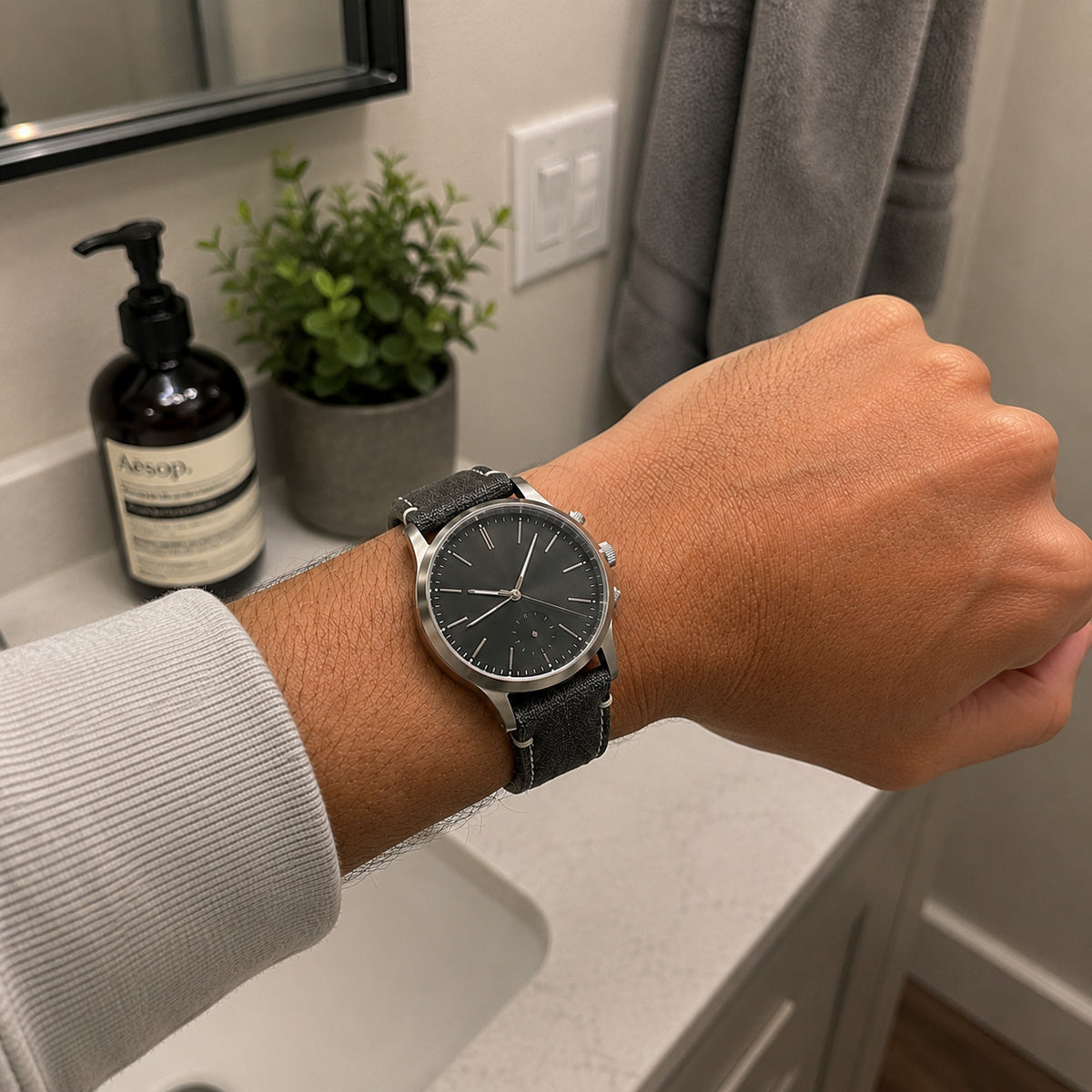 Customer-style iPhone bathroom wrist photo with black canvas strap