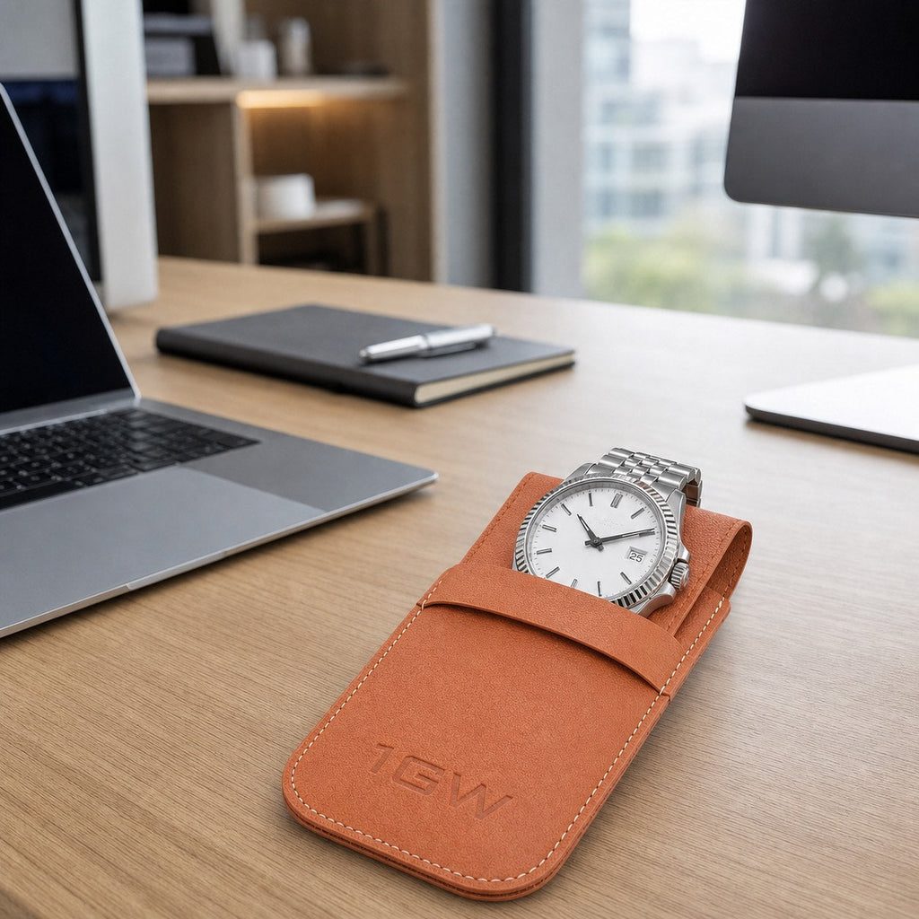 Tan 1GW watch travel pouch with white-dial watch on a modern office desk