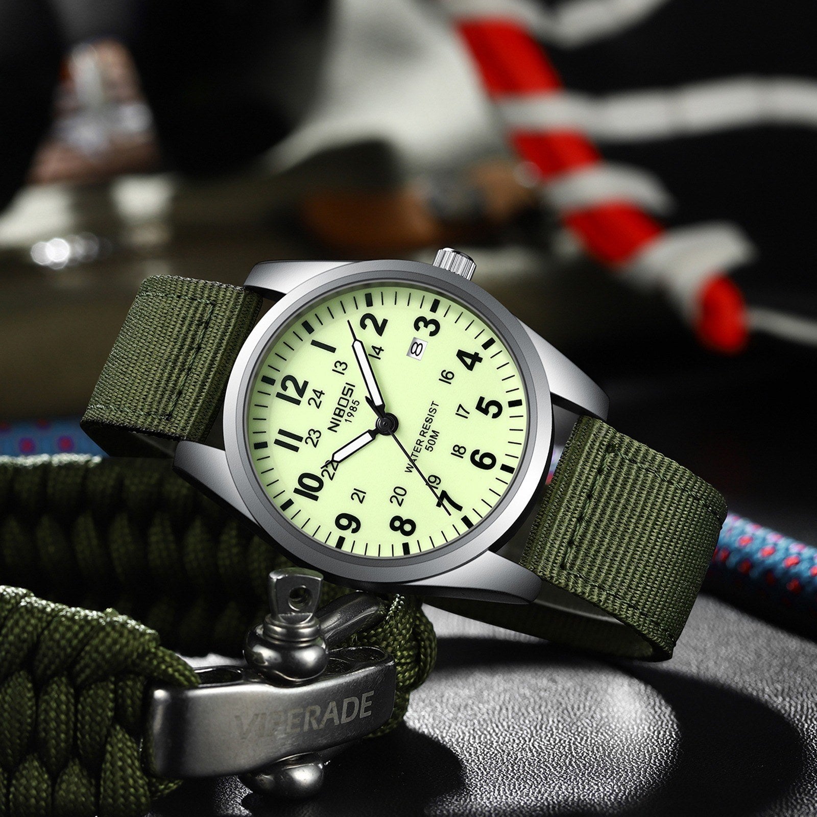 NIBOSI 2639 with cream lume dial resting on paracord and outdoor gear