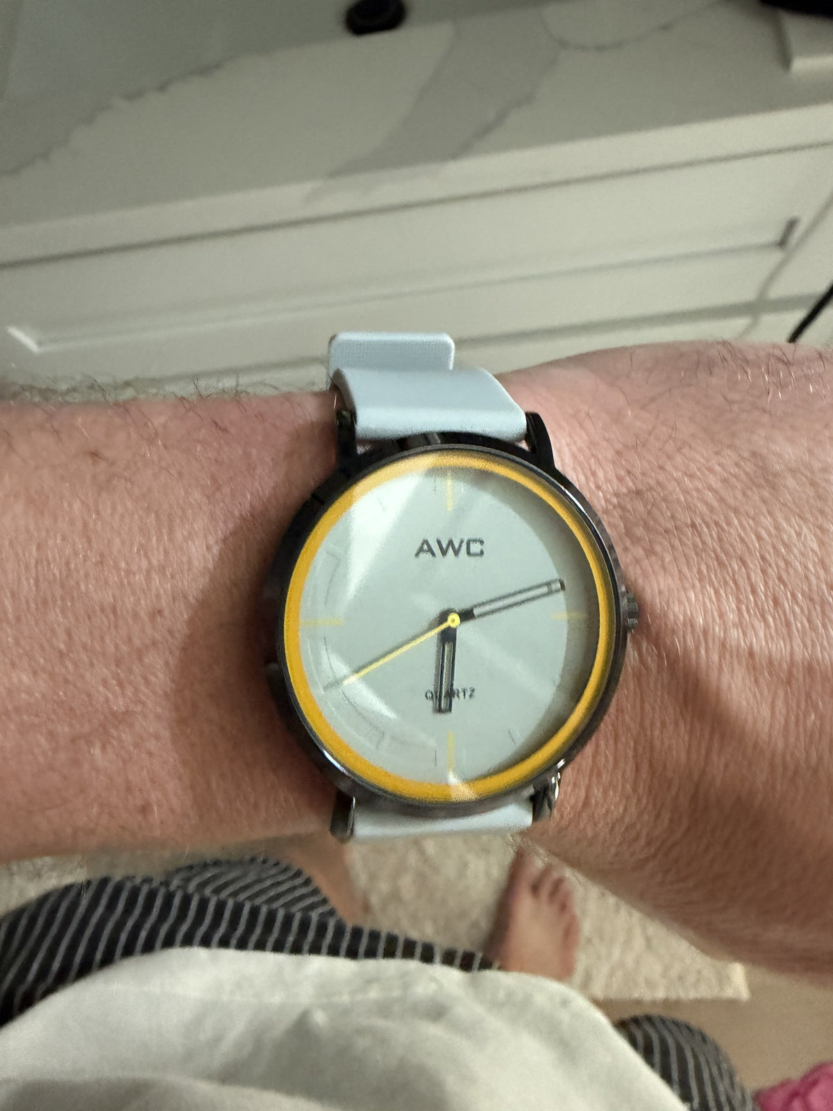 AWC Minimalist Quartz watch, grey dial with yellow ring, white silicone strap on wrist