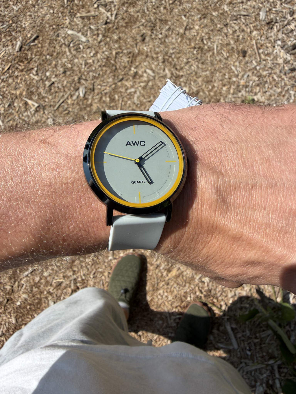 AWC Minimalist Quartz watch, grey dial with yellow ring, angled wrist view in daylight