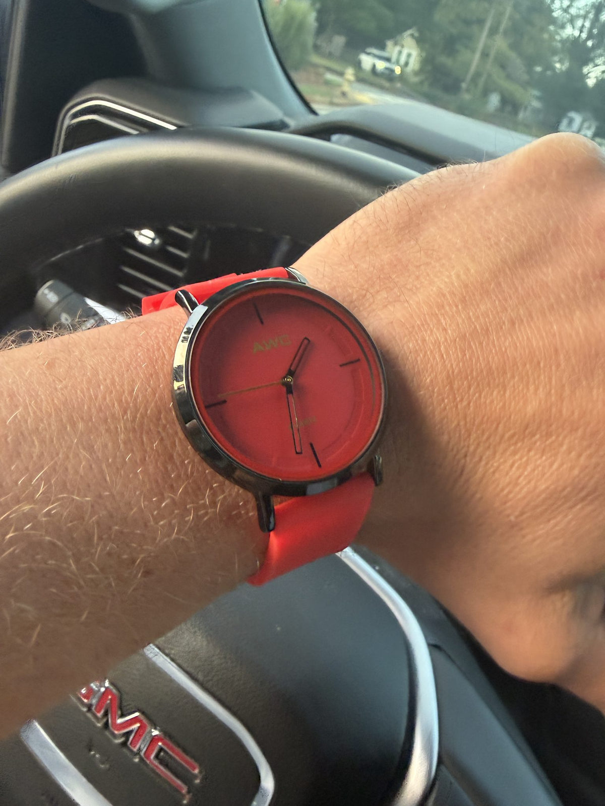 AWC Minimalist Quartz watch, red dial and red silicone strap, worn on wrist while driving