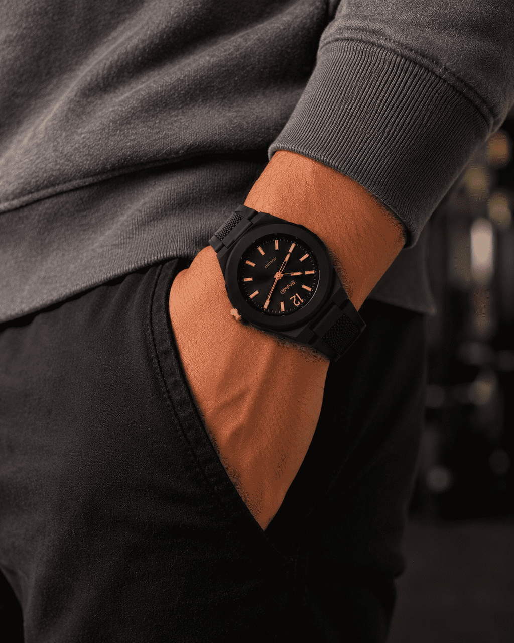 SKMEI 1717 quartz watch, black case with black dial and gold hands, worn on the wrist with a hand in a pocket