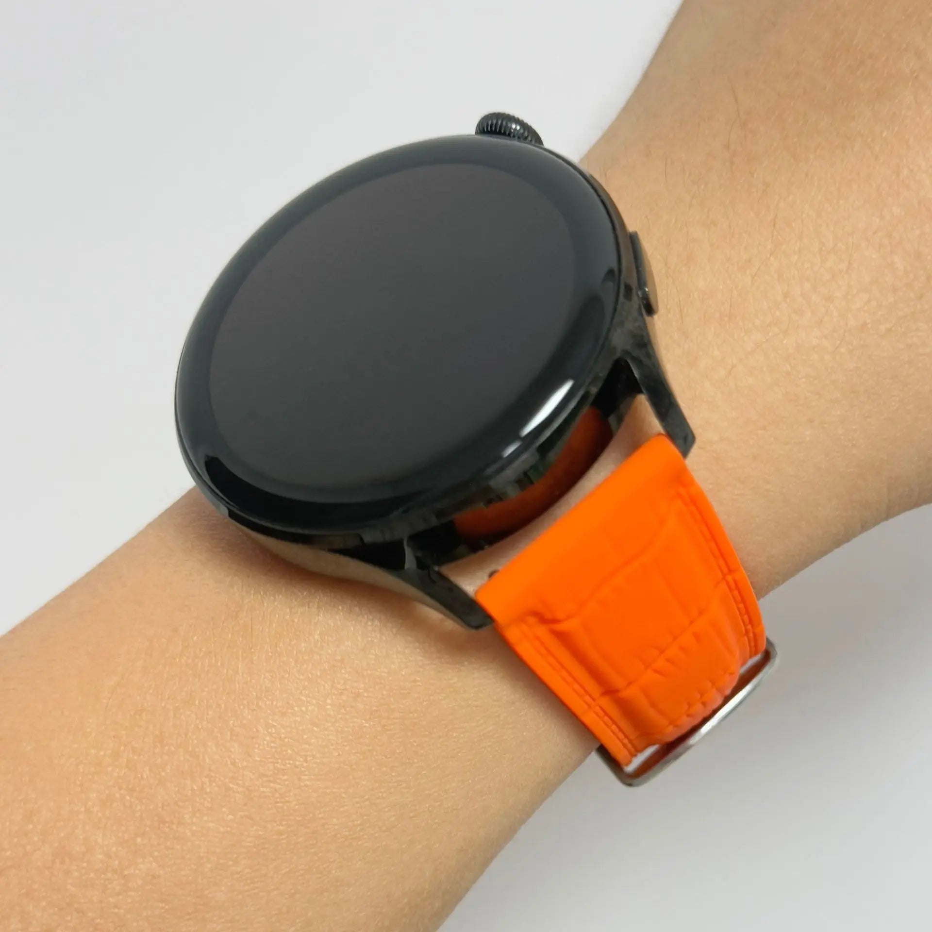 1GW Orange leather-texture silicone watch strap worn on the wrist with a black round watch