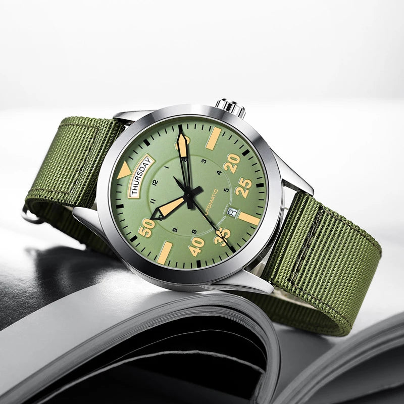 OCHSTIN 62028 green dial automatic field watch with green nylon strap displayed on an open magazine
