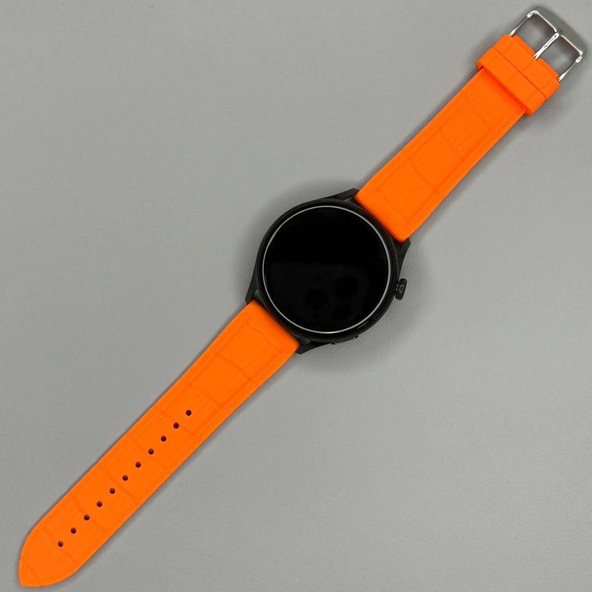 1GW Orange leather-texture silicone watch strap fitted to a black round watch, full strap flat lay
