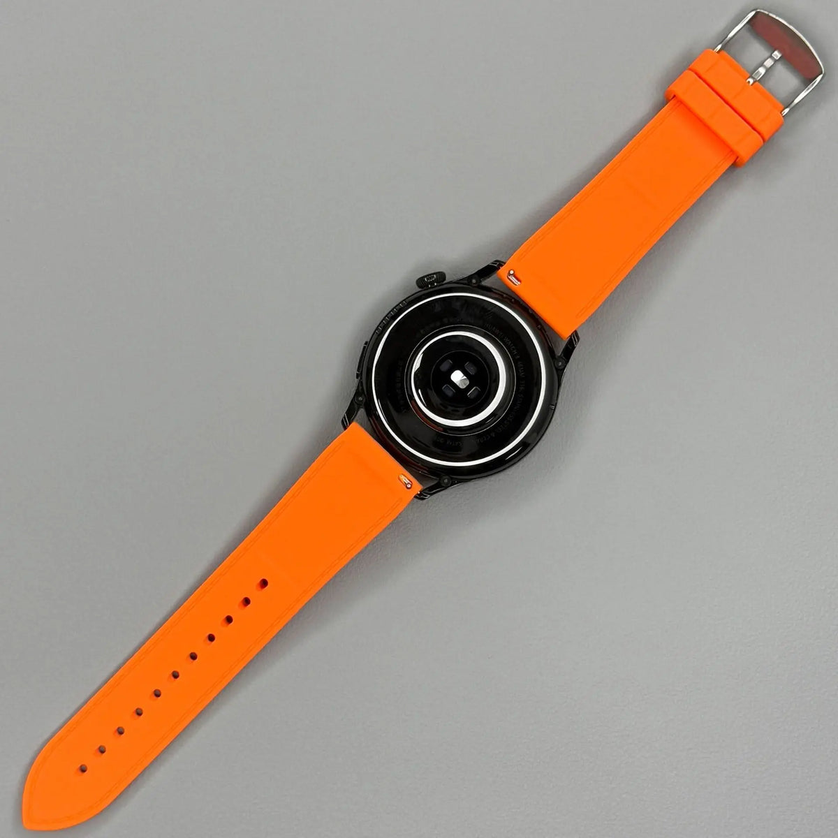 1GW Orange leather-texture silicone watch strap on a watch, top-down view showing the buckle and tail