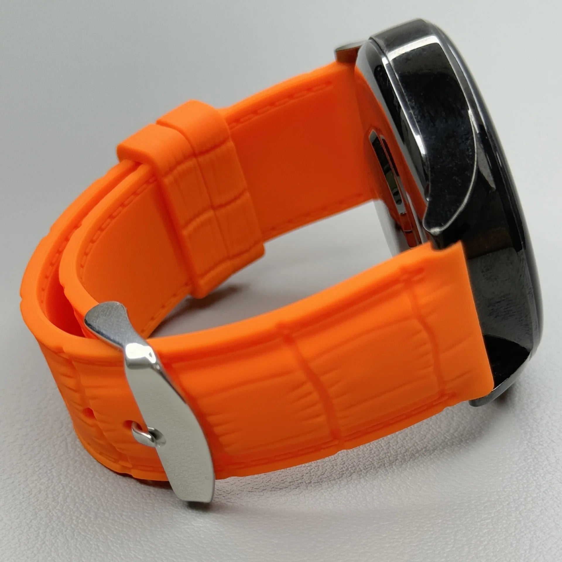 1GW Orange leather-texture silicone watch strap with silver pin buckle, shown fitted to a watch