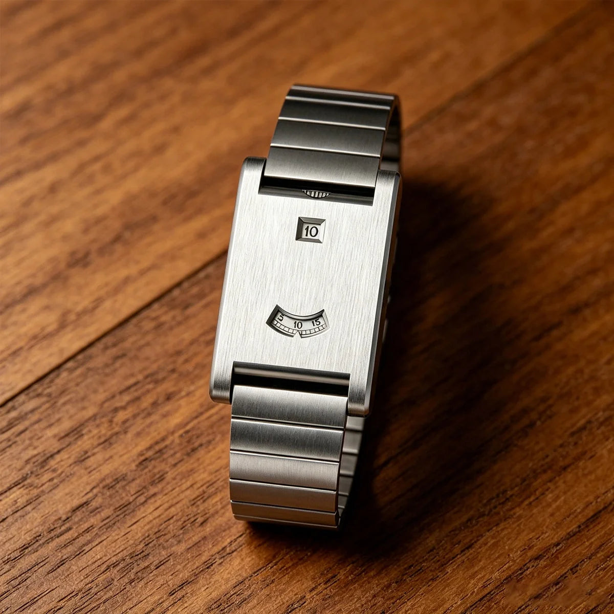 Rolling disc watch with steel bracelet on a wood table
