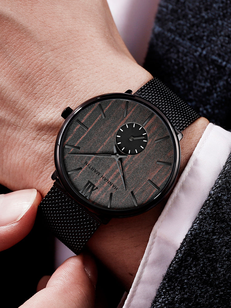 HANNAH MARTIN 3D Wood Stripe 40mm, dark wood dial on black mesh, worn with a shirt cuff