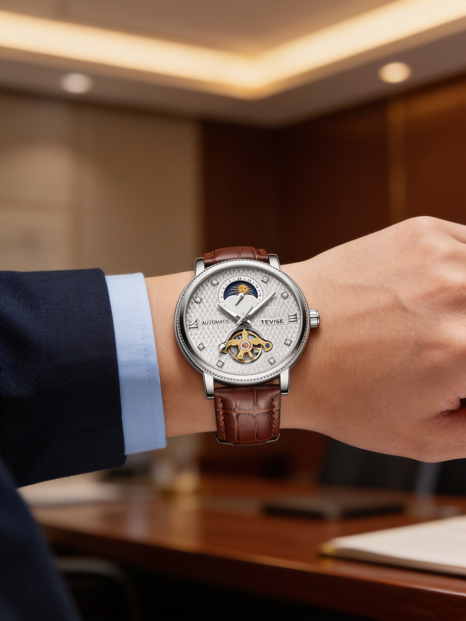 TEVISE silver-white open-heart automatic dress watch with brown leather strap, worn on wrist in a boardroom