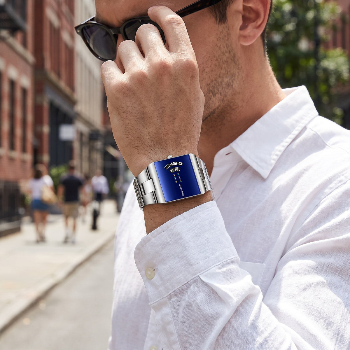 VA VA VOOM 2693 Rectangle watch, silver case with blue dial, worn on the wrist outdoors on a city street