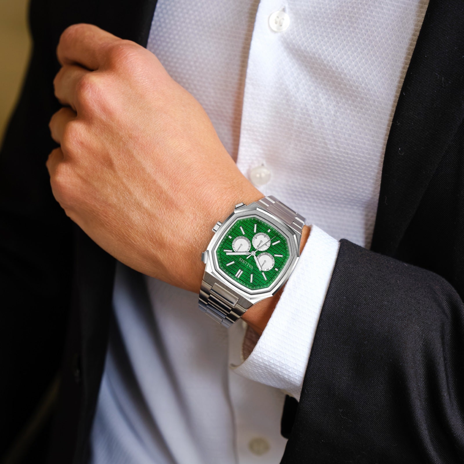 VALUSIS Volt green chronograph automatic watch worn on a wrist with a white dress shirt and dark suit
