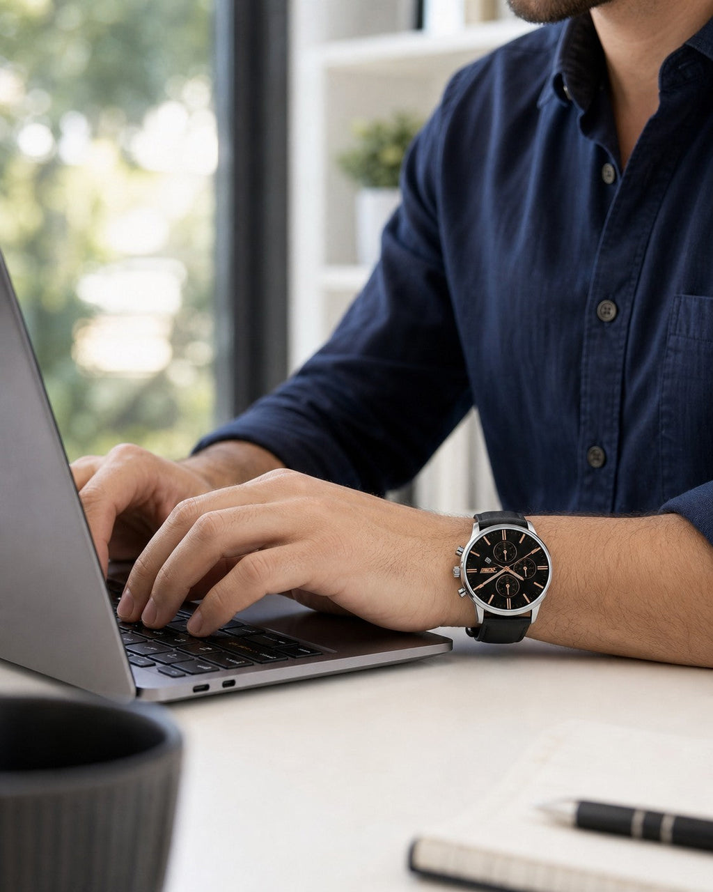 SKMEI 9103 black dial chronograph with black leather strap worn while working on a laptop