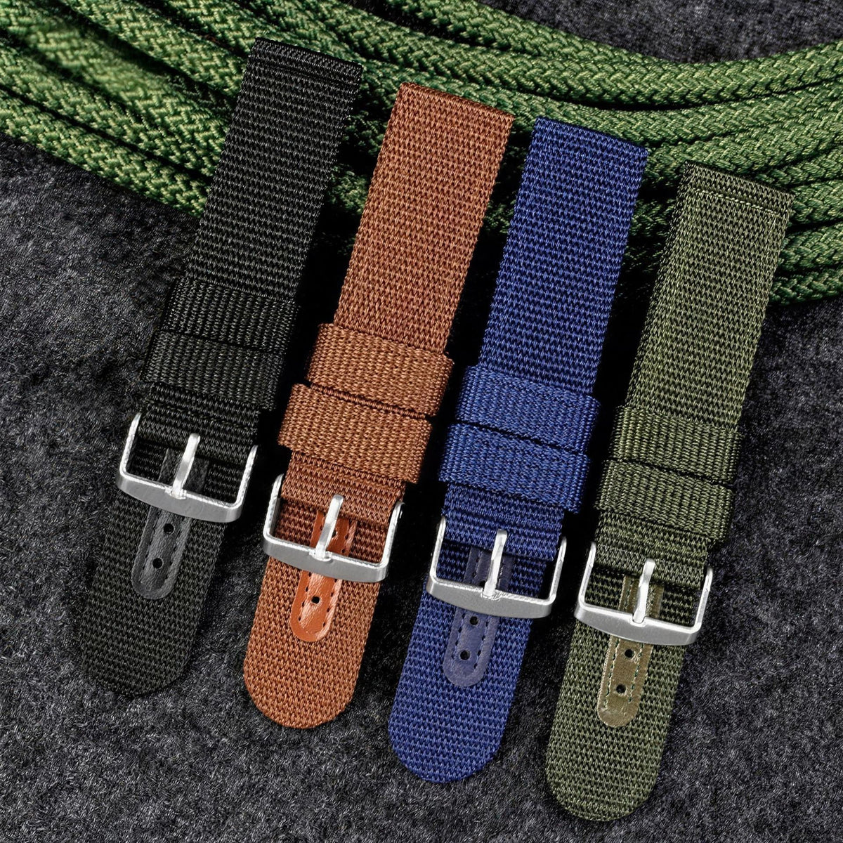 UPro Classic Ballistic Nylon watch straps in black, brown, blue and green laid out on a dark slate surface