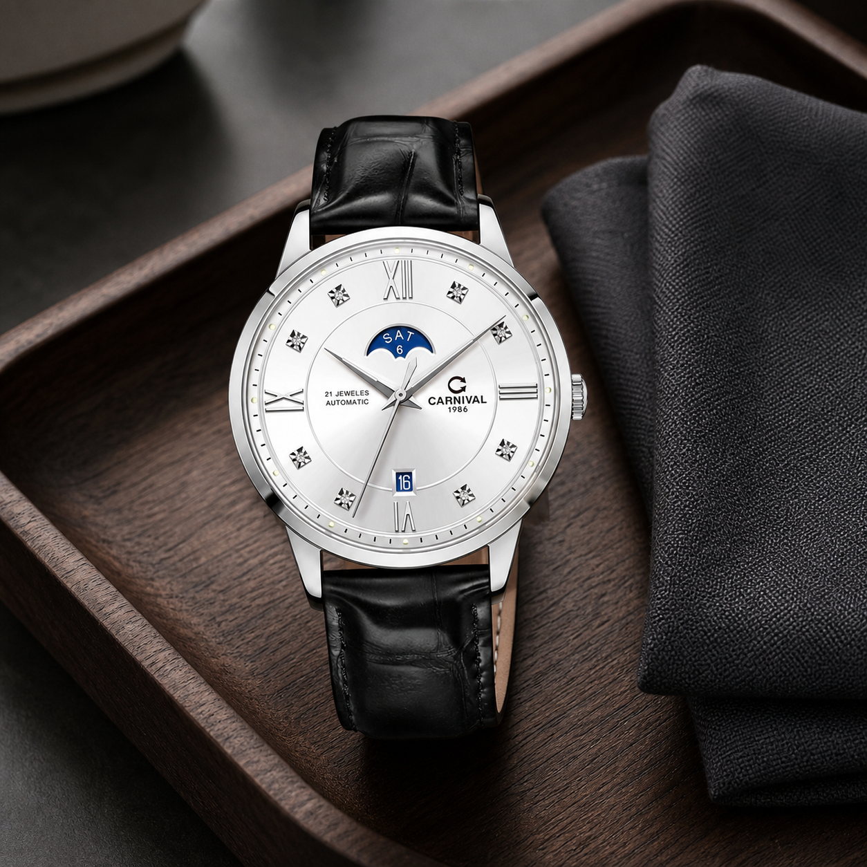 Carnival CG8097G white-dial moonphase automatic watch with black leather strap on a walnut valet tray