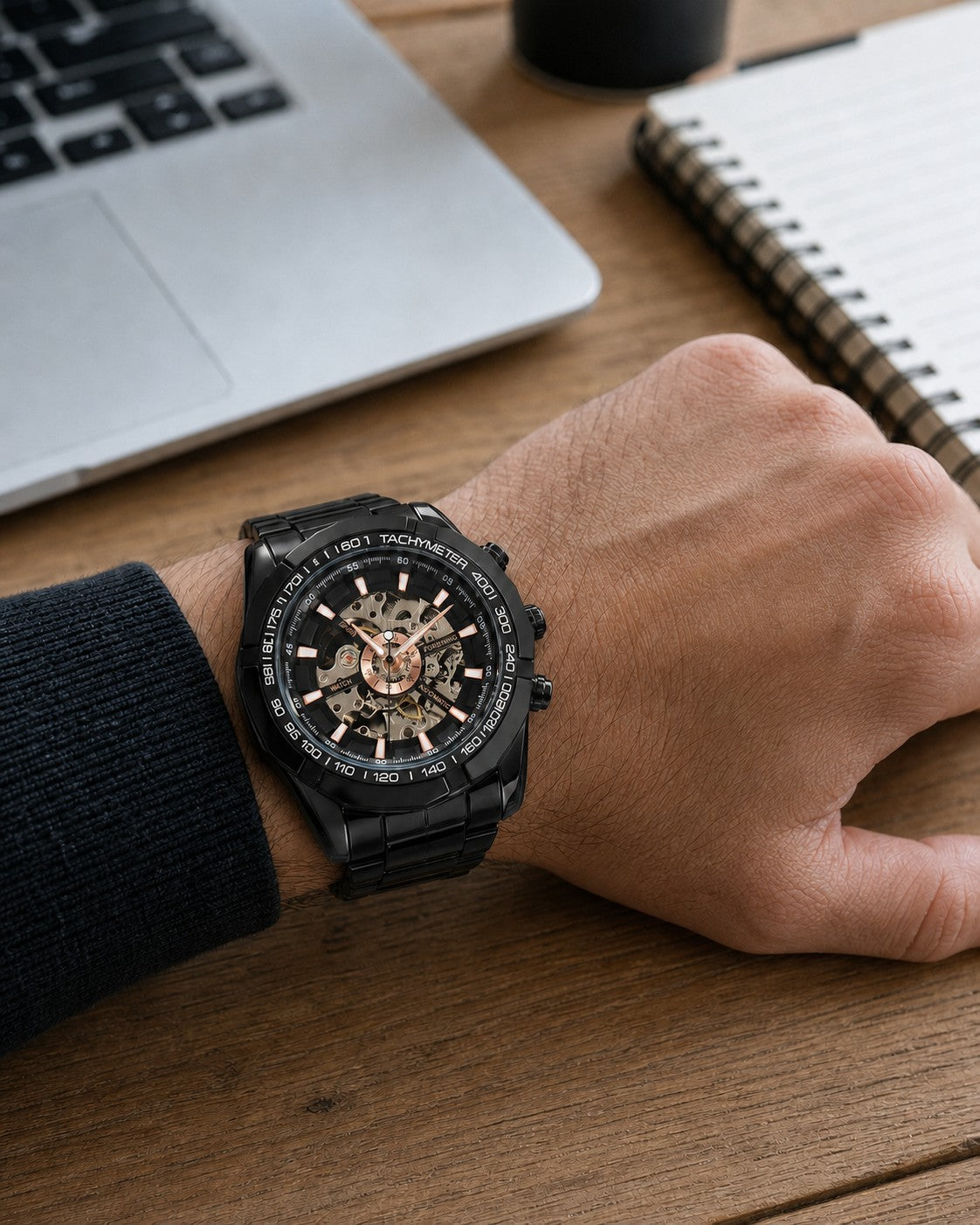 FORSINING F-013 Black skeleton mechanical watch worn on wrist at a desk