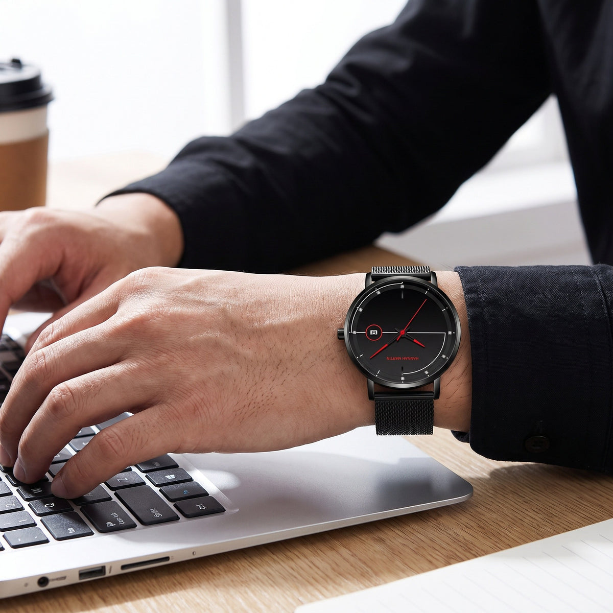 HANNAH MARTIN Minimalist Calendar 40mm, black dial with red hands, worn on the wrist while typing on a laptop