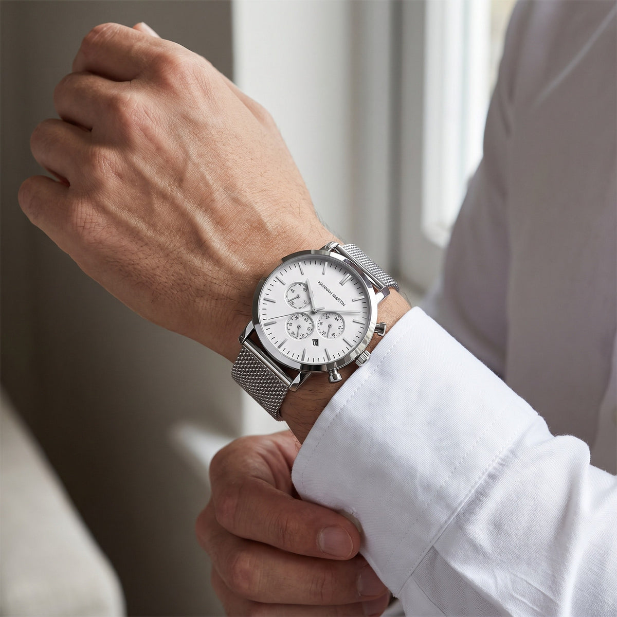 HANNAH MARTIN Three-Subdial Mesh 45mm, white dial and silver mesh, worn with a white dress shirt cuff