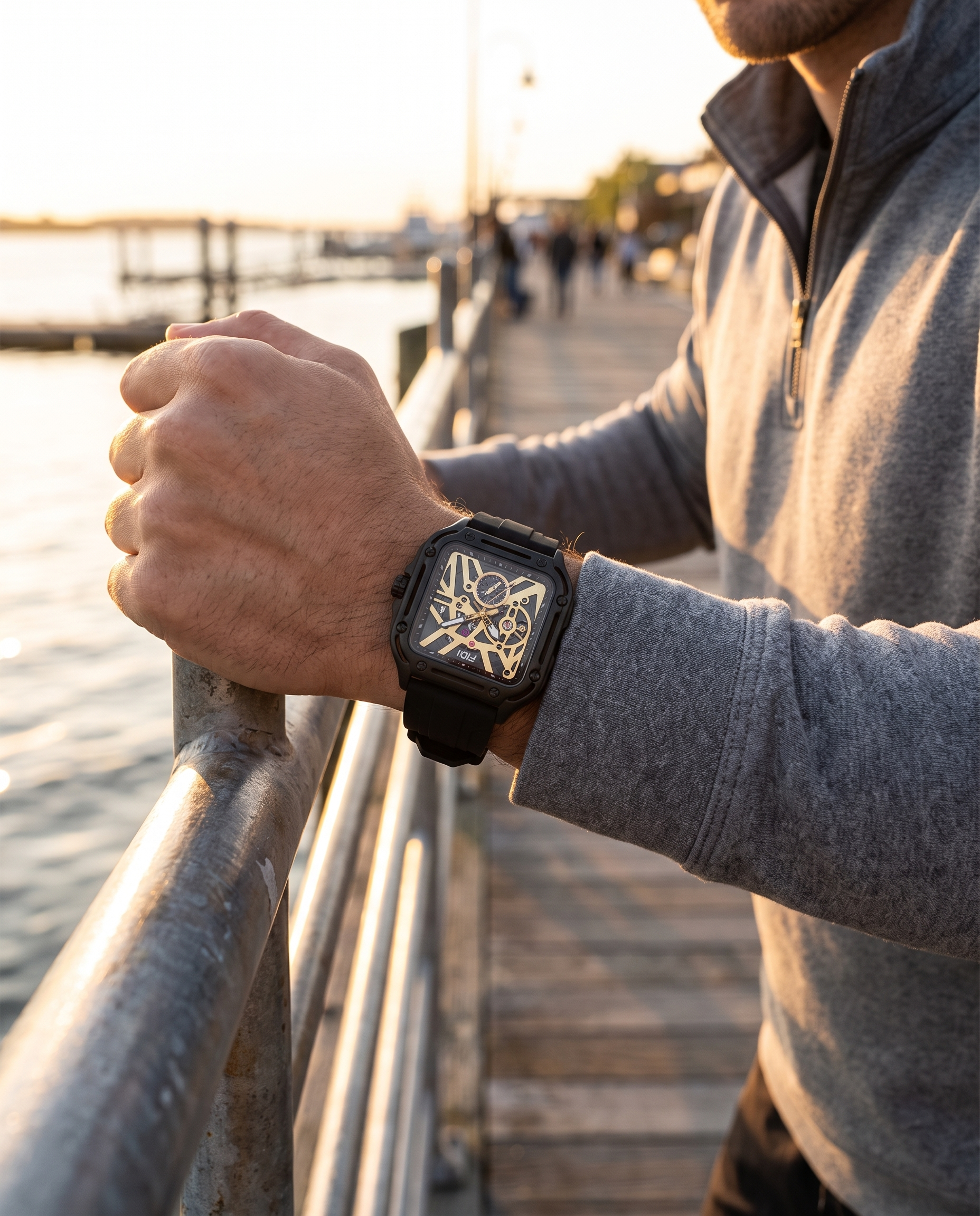 Man on boardwalk wearing FIDI black and gold square skeleton automatic watch