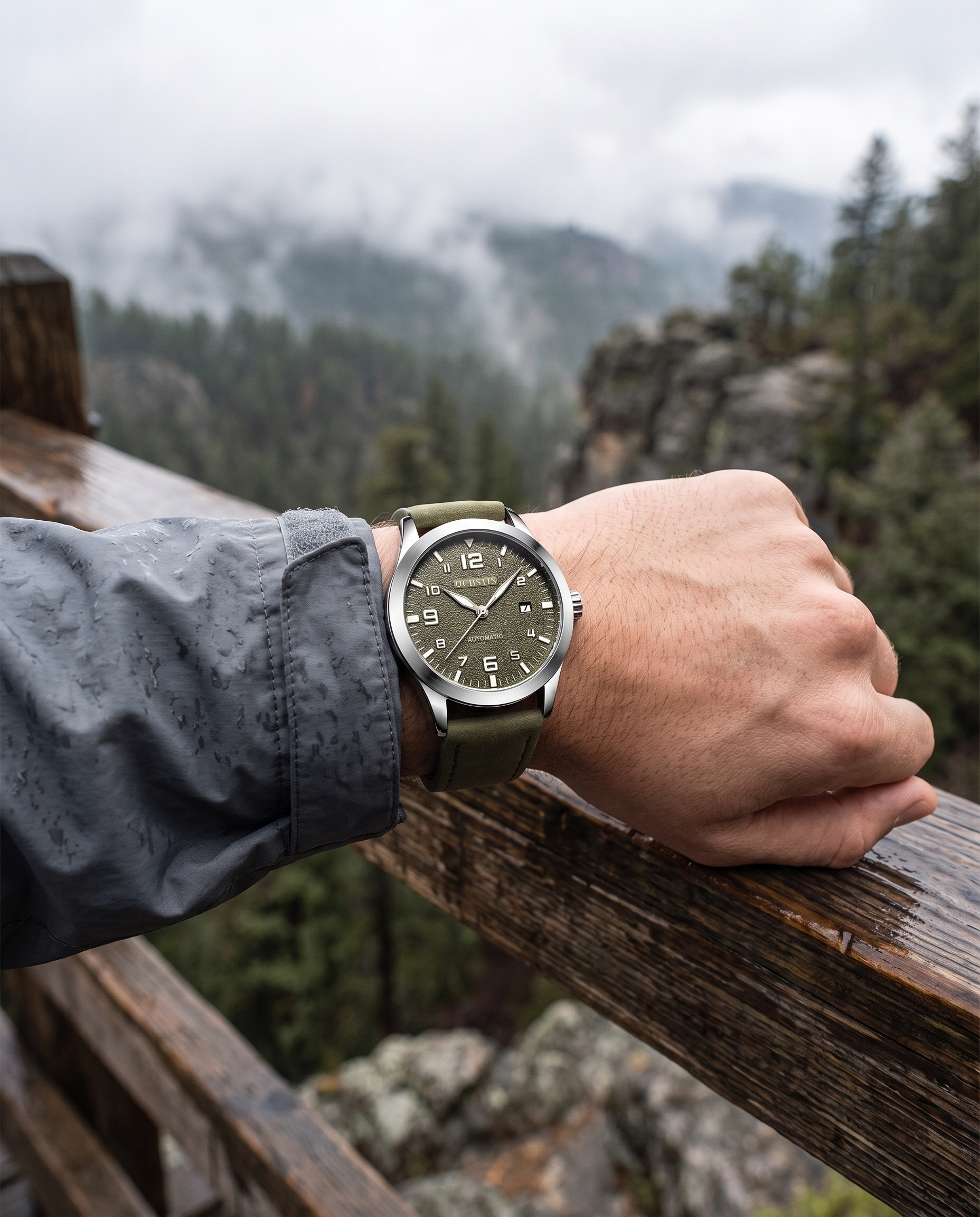 Man at mountain overlook wearing OCHSTIN green automatic watch