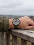 SYNOKE retro quartz watch with green leather strap worn outdoors