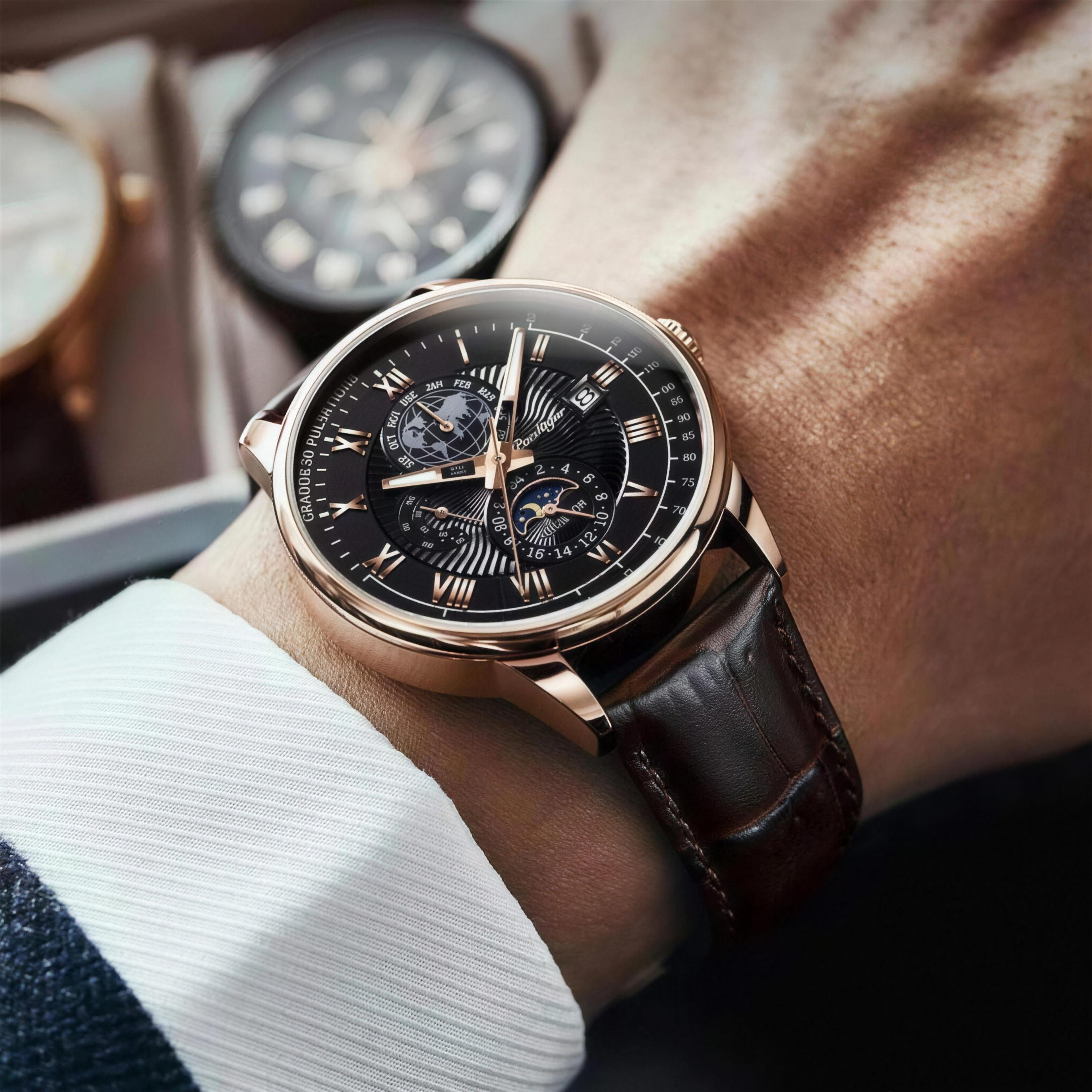 POEDAGAR rose gold case and black dial layered-dial quartz watch worn on wrist