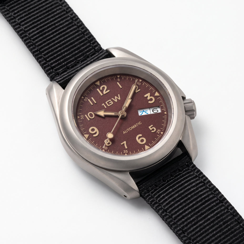 1GW Burgundy Field Day-Date Titanium 40mm - high three-quarter studio angle on white showing titanium case side, crown and lug profile