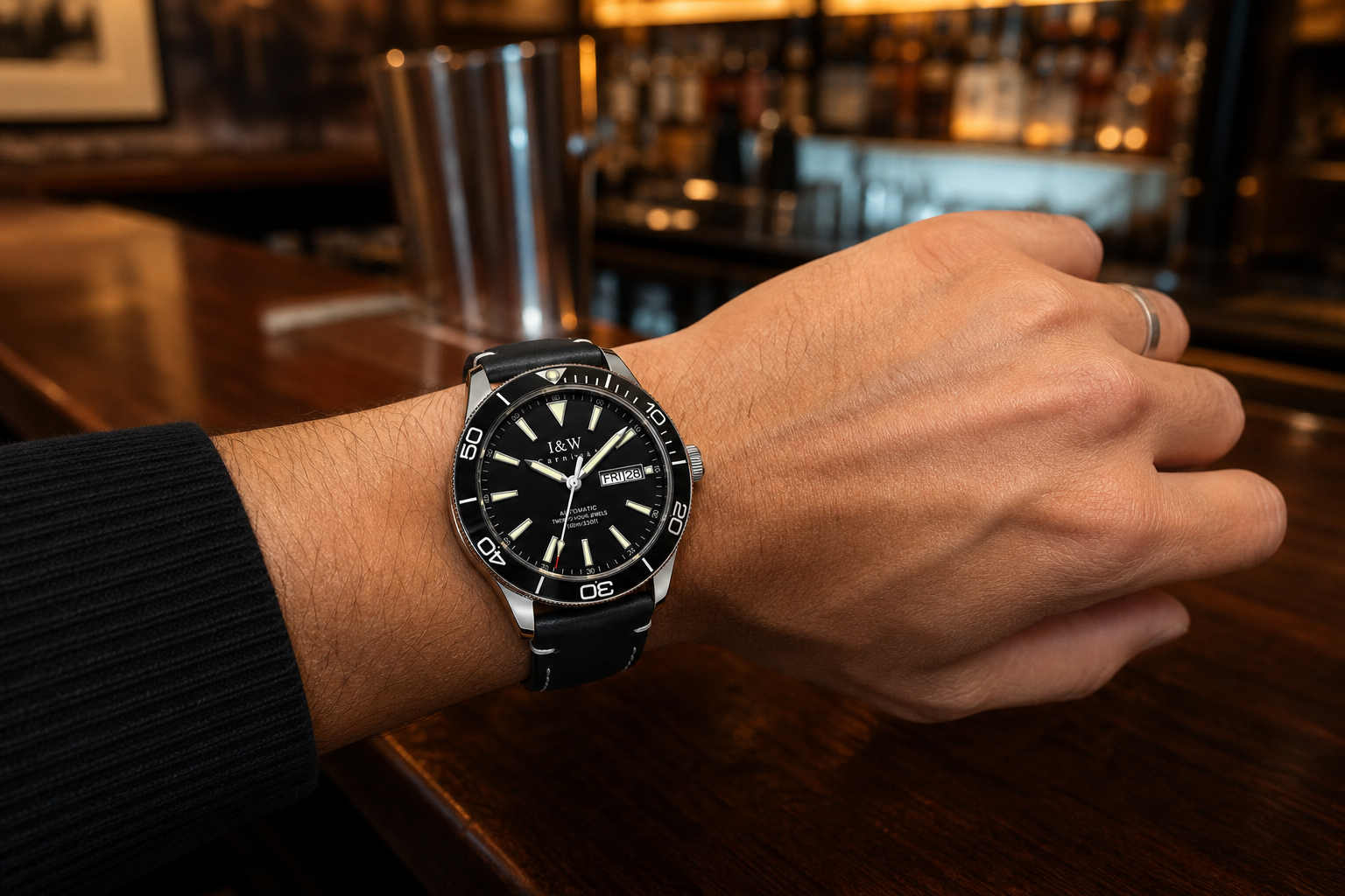 Carnival I&W IW.533G automatic watch worn on wrist at a walnut bar, branded dial