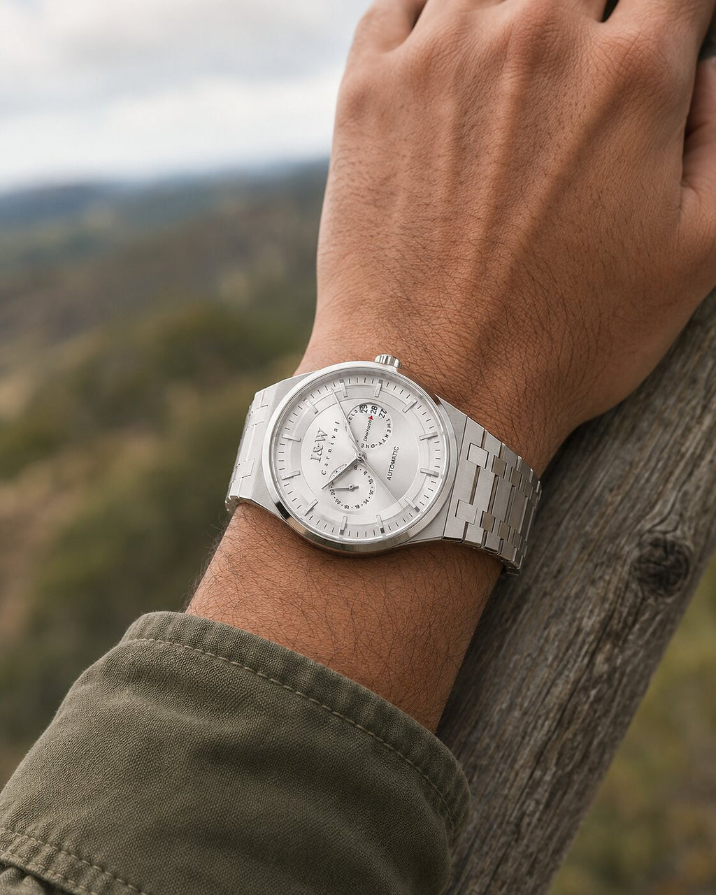 Man wearing Carnival IW55870G white dial automatic watch with steel bracelet outdoors