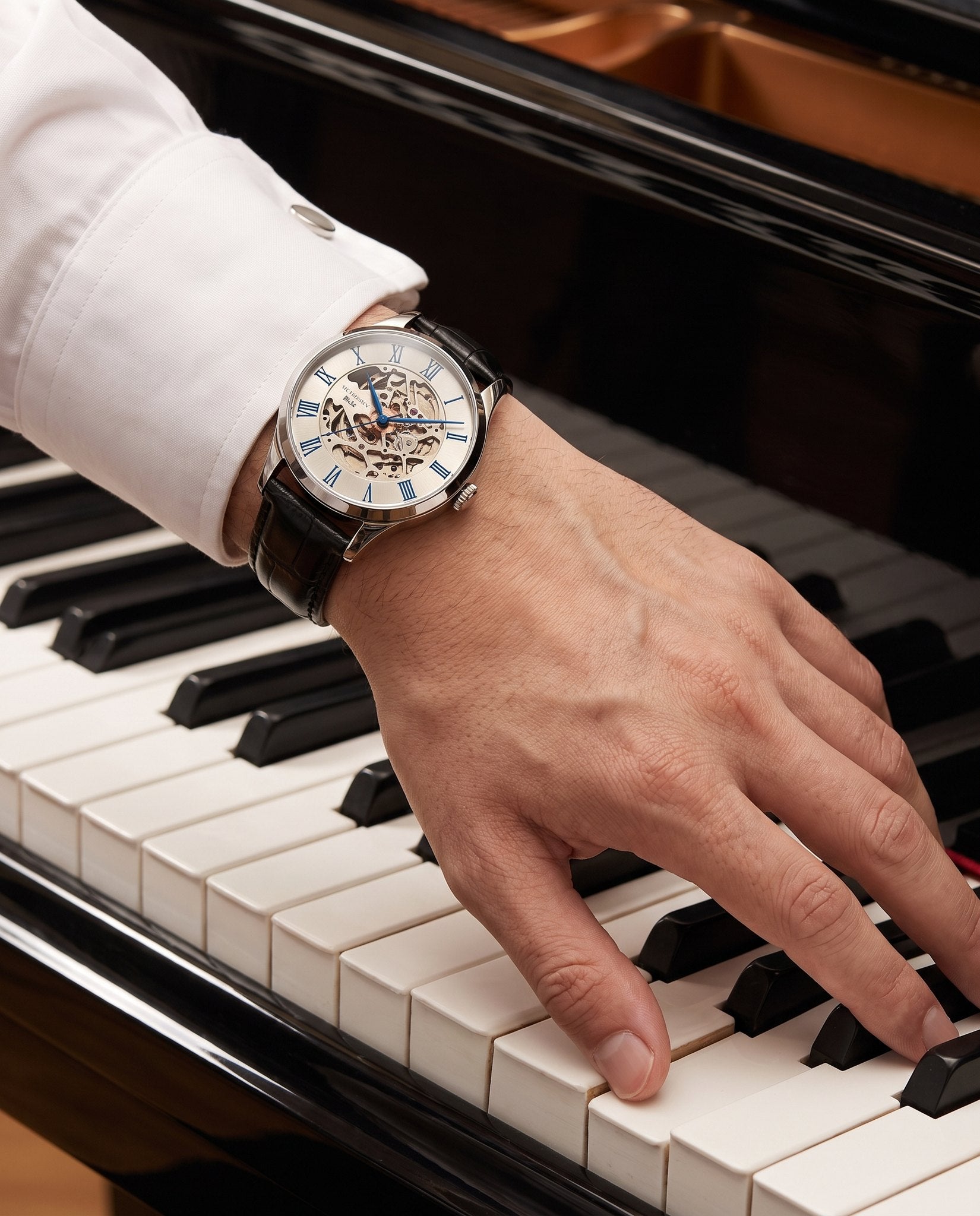Carnival IW.652G worn on the wrist at a piano with a French-cuff shirt
