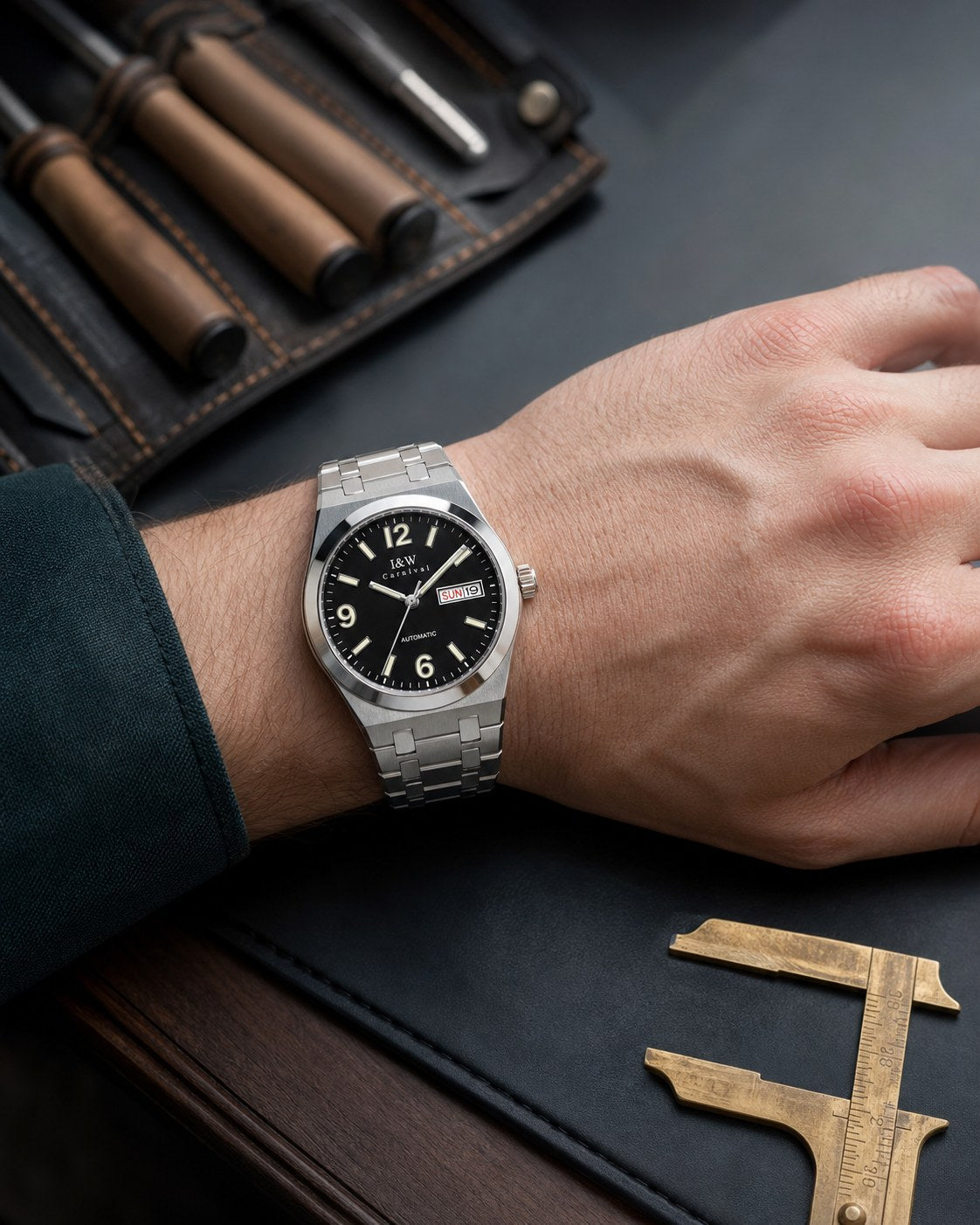 Carnival black day-date automatic watch on wrist at a workshop bench
