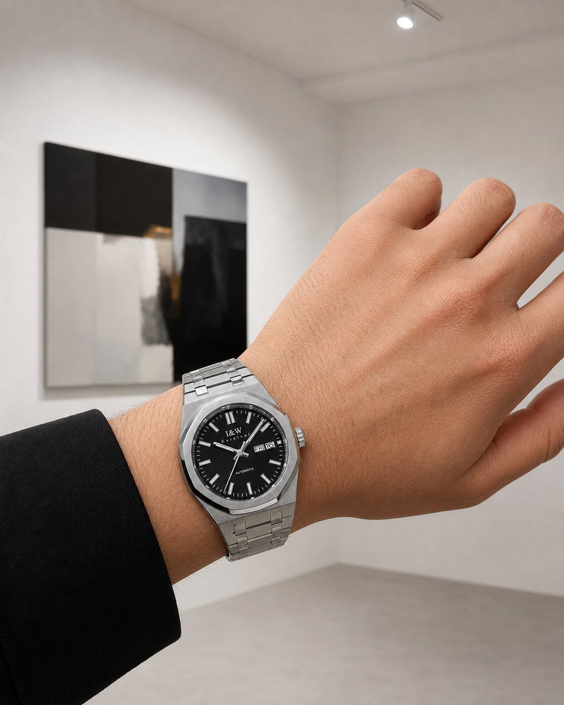 Carnival black-dial integrated-bracelet automatic watch on wrist in an art gallery