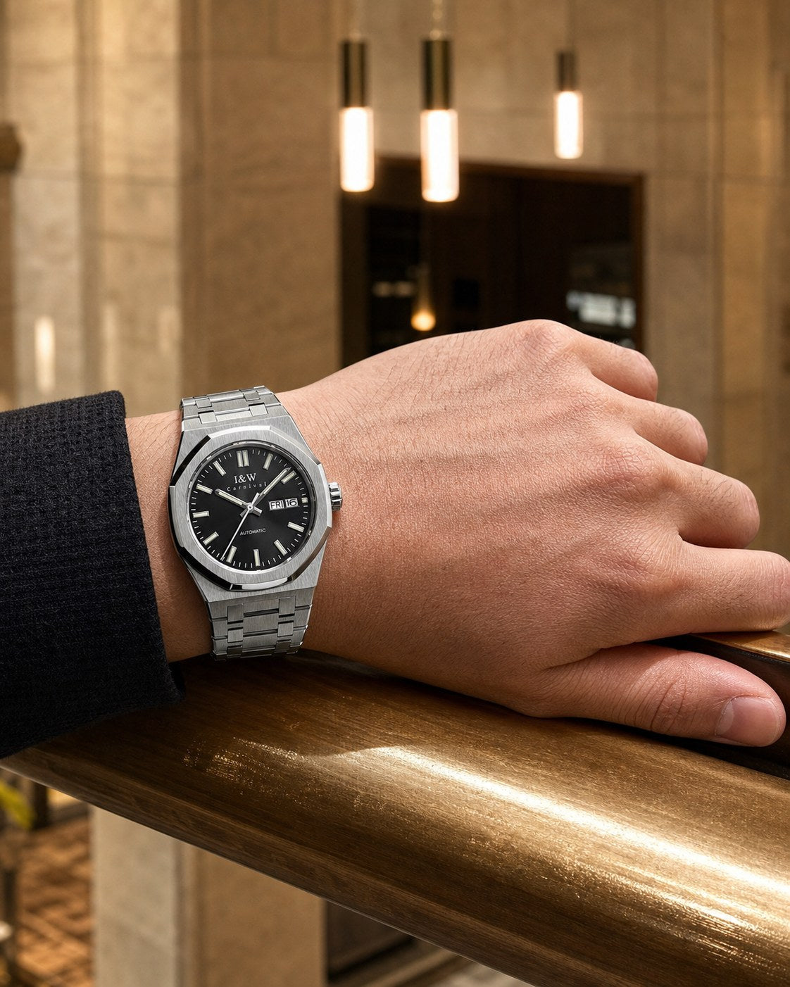 Carnival black-dial integrated-bracelet automatic watch on wrist at a hotel rail