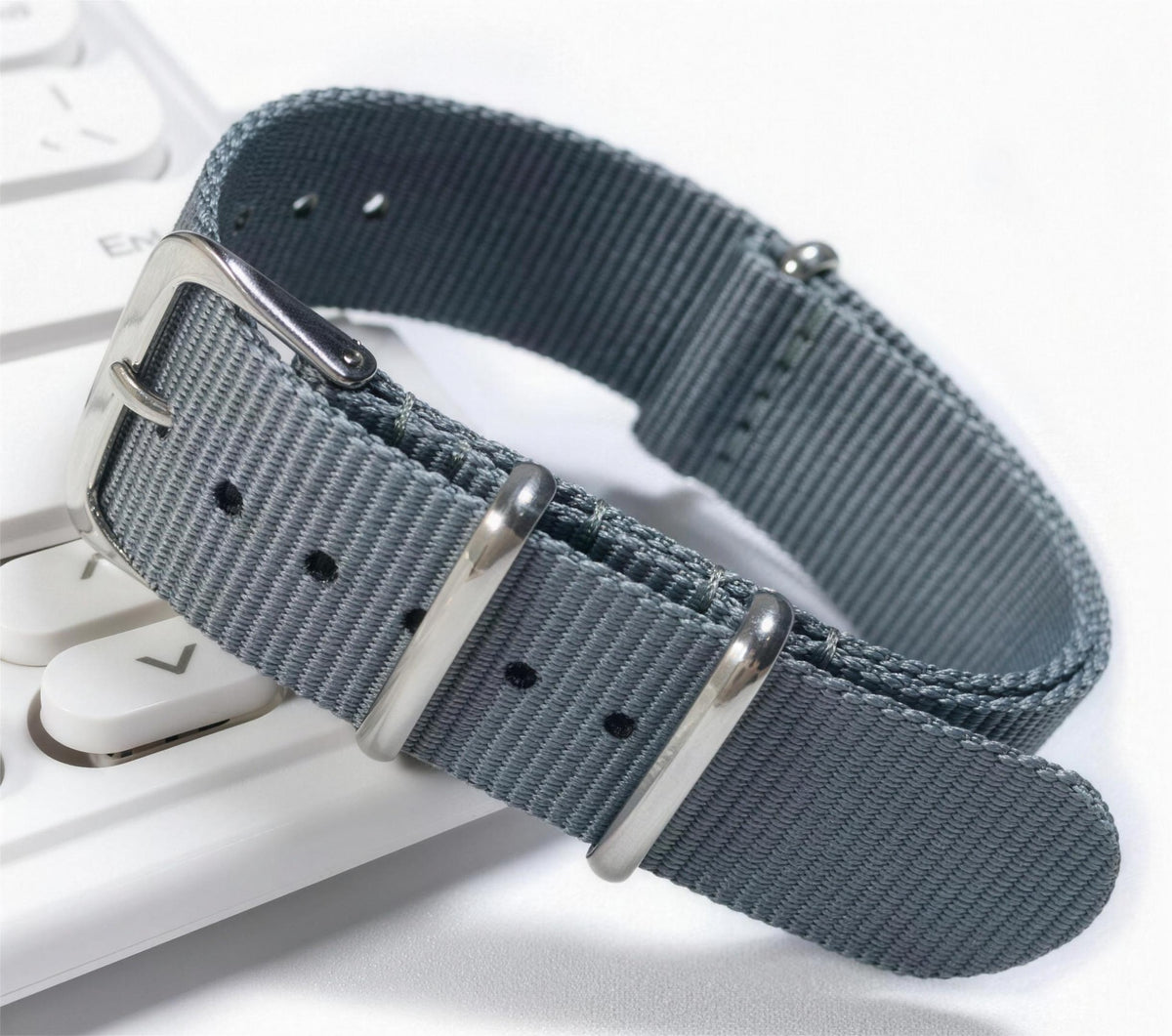 Gray woven nylon pass-through watch strap with brushed steel keepers and pin buckle