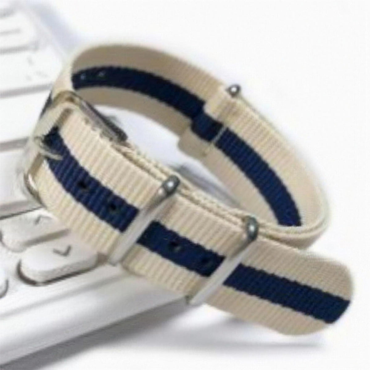 Khaki and navy striped woven nylon pass-through watch strap, coiled to show the weave