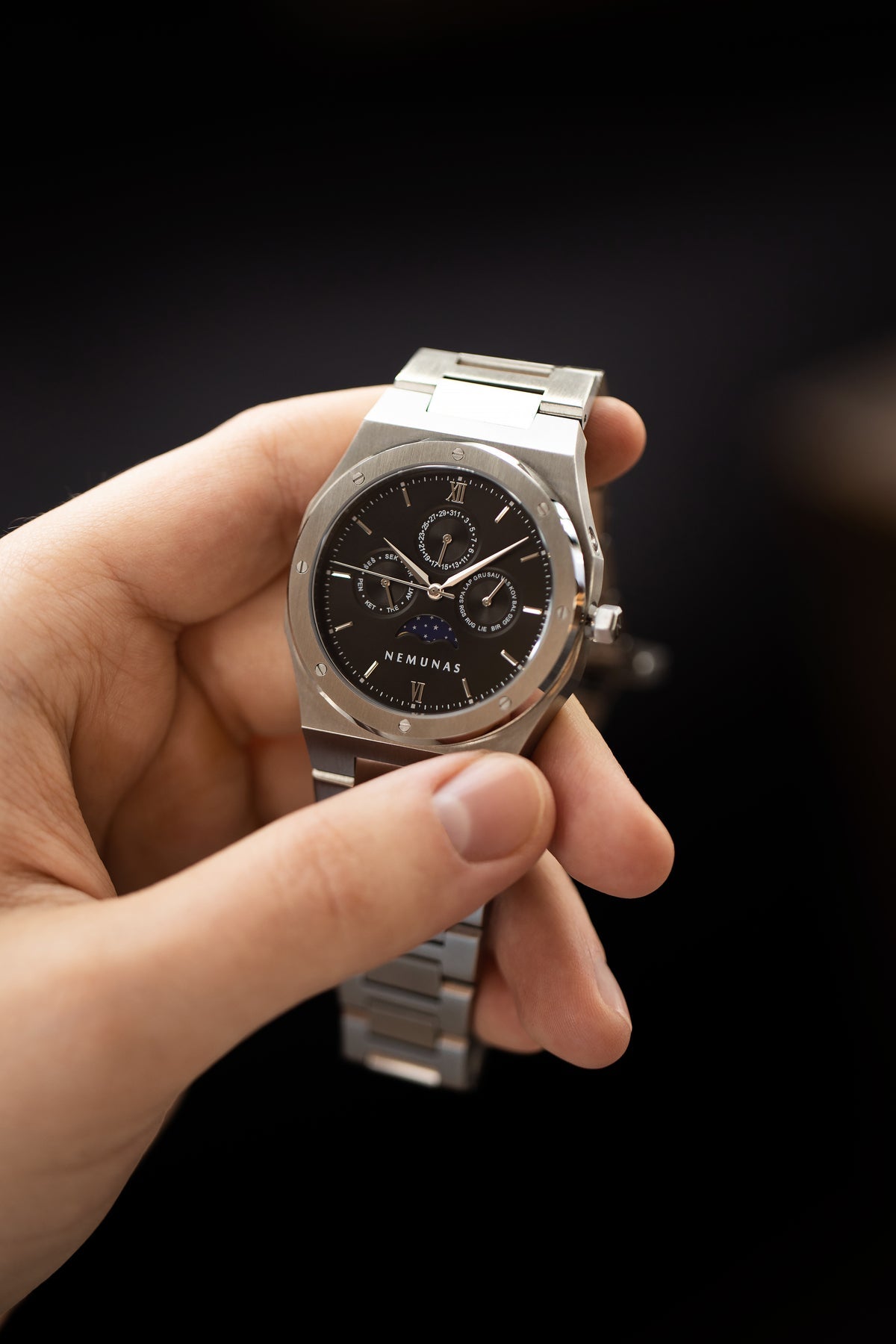 NEMUNAS Perkunas black and silver watch held in hand