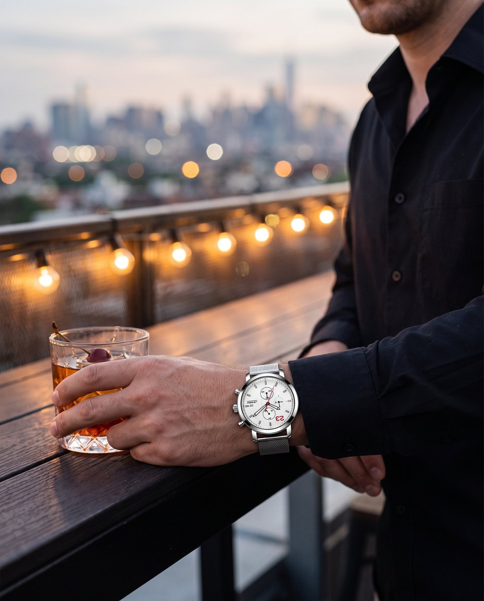 Man at a rooftop bar at dusk wearing the SINOBI S9765G white chronograph with steel mesh bracelet