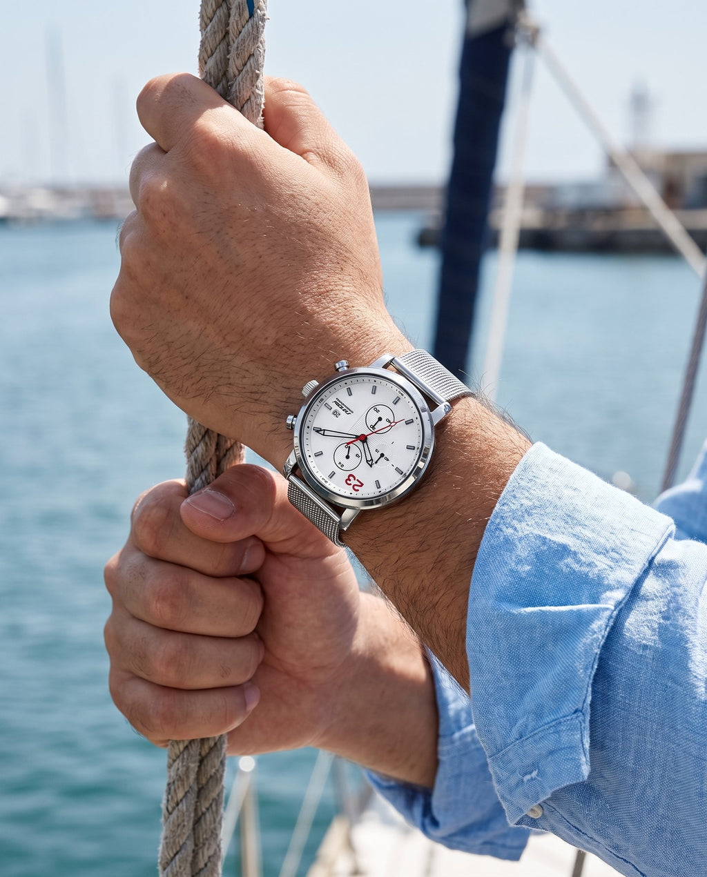 Man on a sailboat wearing the SINOBI S9765G white chronograph with steel mesh bracelet
