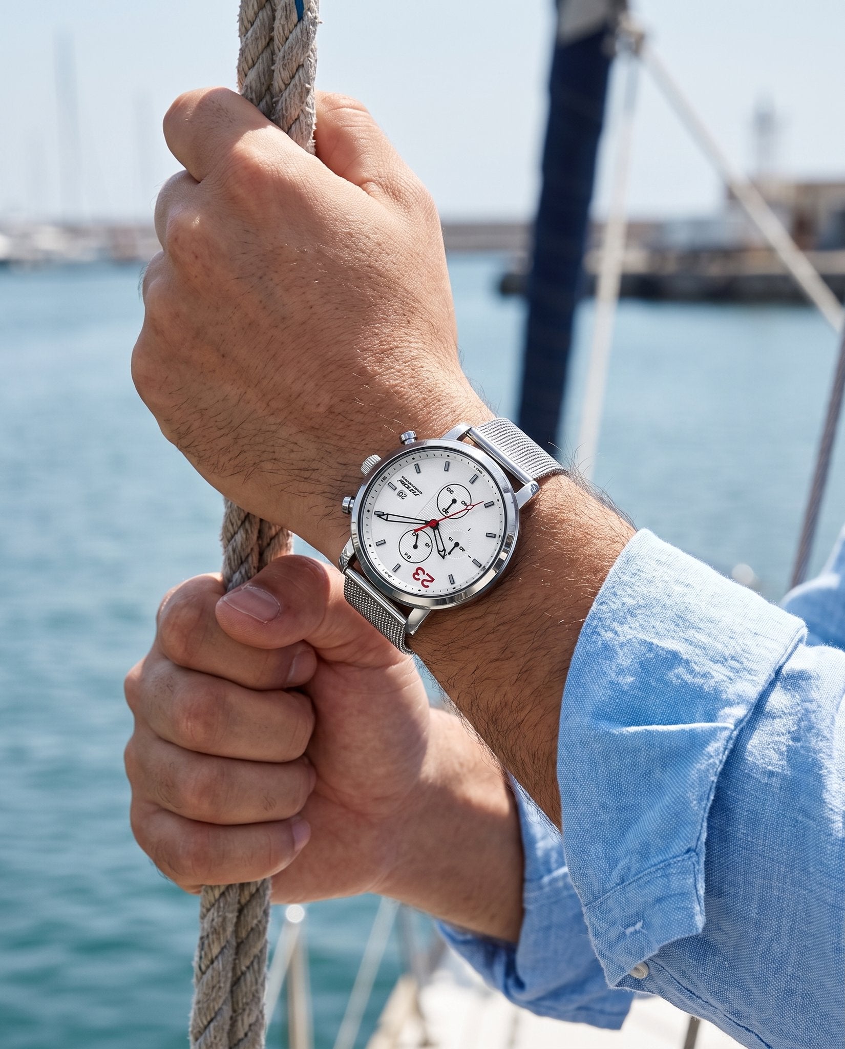 Man on a sailboat wearing the SINOBI S9765G white chronograph with steel mesh bracelet